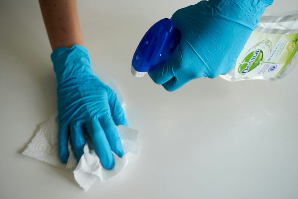 Worker of Liberty Diensten cleaning table with blue gloves
